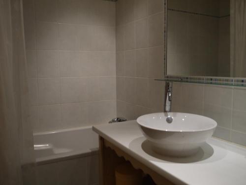 een badkamer met een wastafel met een spiegel en een bad bij Appartement Méribel, 2 pièces, 5 personnes - FR-1-355-33 in Méribel