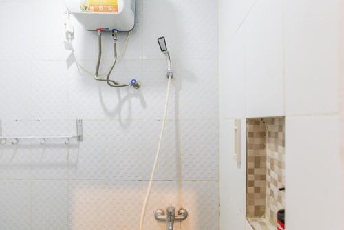 y baño con ducha con manguera pegada a la pared. en RedDoorz Plus Syariah near Mall Pondok Indah, en Yakarta