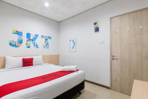 um quarto com uma cama e uma porta de madeira em RedDoorz Plus Syariah near Mall Pondok Indah em Jakarta