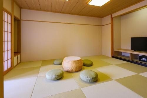 ein Wohnzimmer mit einem Tisch und einem TV in der Unterkunft TAOYA Akiu in Sendai