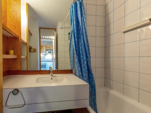 a bathroom with a sink and a blue shower curtain at Appartement La Plagne, 3 pièces, 6 personnes - FR-1-353-8 in La Plagne