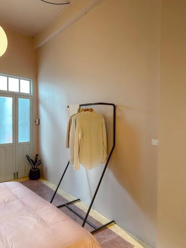 a yellow shirt hanging on a wall in a room at Cozy Room at The Coffee Store Charoenkrung in Bangkok