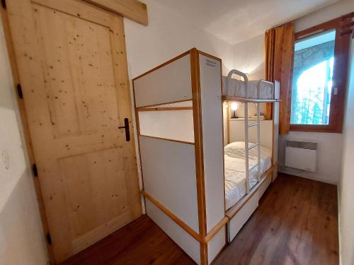 ラ・プラーニュにあるAppartement La Plagne, 2 pièces, 6 personnes - FR-1-353-64の二段ベッドとドアが備わる小さな客室です。