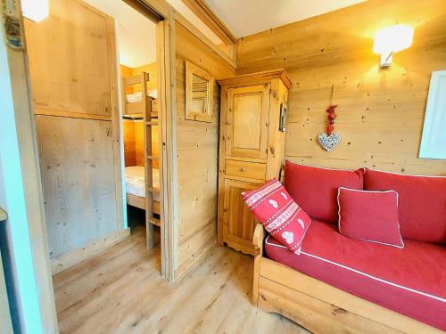 ein Wohnzimmer mit einer roten Couch in einer Hütte in der Unterkunft Appartement La Plagne, 1 pièce, 4 personnes - FR-1-351-29 in La Plagne