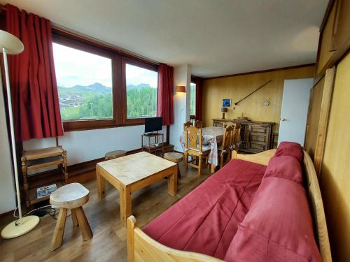 a bedroom with a bed and a table and a window at Appartement La Plagne, 2 pièces, 5 personnes - FR-1-351-30 in La Plagne