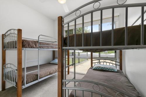two bunk beds in a room with a window at THE Beach Hive - Wifi, PET Friendly Outside Only - Inlet Side in Inverloch