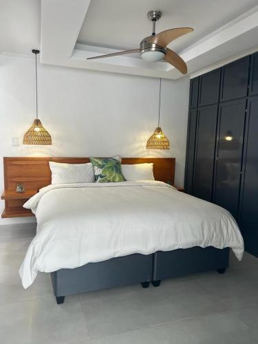 a bedroom with a large bed with a ceiling fan at Villa Le Rosa Unit 5 in Durban