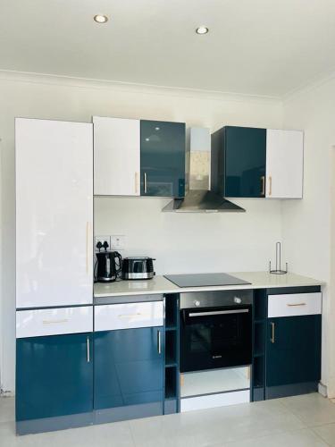 a kitchen with blue and white cabinets and appliances at Villa Le Rosa Unit 5 in Durban