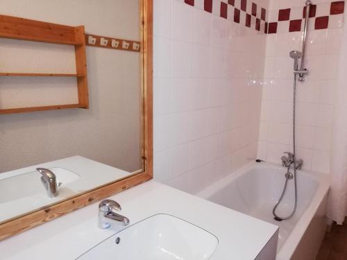 a bathroom with a sink and a tub and a mirror at Appartement Les Avanchers-Valmorel, 2 pièces, 5 personnes - FR-1-356-356 in Valmorel