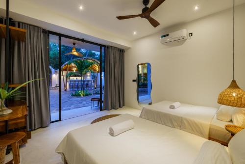 a hotel room with two beds and a large window at Terra Resort in Ahangama