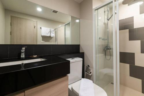 een badkamer met een toilet, een wastafel en een douche bij Modern Condo in Nimman (F407) by Pimolplace in Chiang Mai