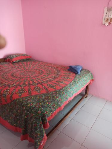 ein Schlafzimmer mit einem Bett in einem rosa Zimmer in der Unterkunft Om Ganesh Naik Guest House in Arambol