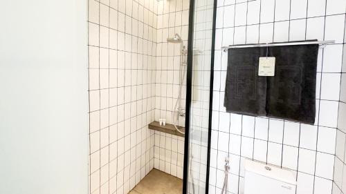 een badkamer met een douche en een zwarte handdoek bij REZ Hotel in Semarang