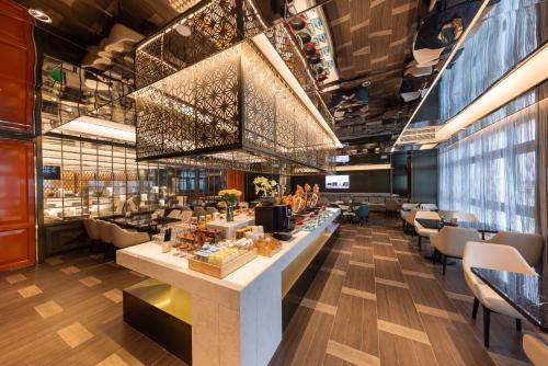 a lobby of a restaurant with a counter and chairs at Shenzhen Futian Huaqiangbei Pedestrian Street Atour Hotel in Shenzhen