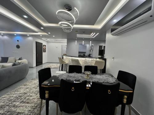 ein Esszimmer mit einem Tisch und einem Sofa in der Unterkunft شقة فندقية في مدينتي in Madinaty