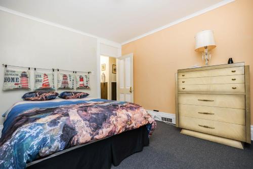 a bedroom with a bed and a dresser at Wolseley the heart of the city ! in Winnipeg