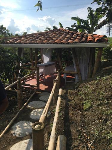 a small building with a roof on top of it at Villa Luzandi in Quimbaya