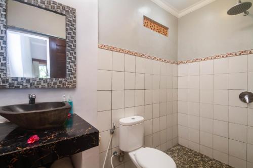 a bathroom with a sink and a toilet at Parthi Puri Ubud in Ubud