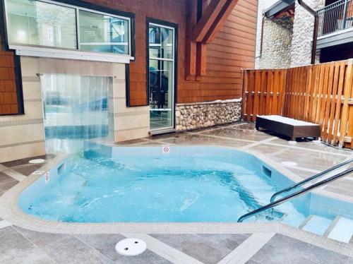 a hot tub in the backyard of a house at Family Fun- MTN View Stay, Water slide, Pool, Hot Tub, Free Parking in Canmore