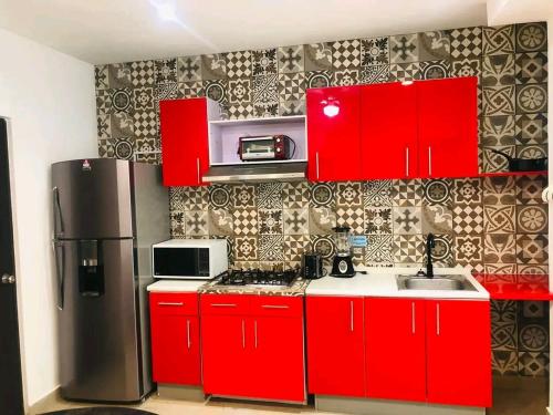kuchnia z czerwonymi szafkami i lodówką w obiekcie Loft estudio centrico w mieście Ciudad del Carmen