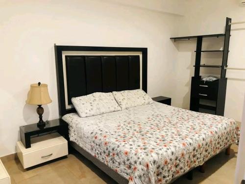 a bedroom with a bed with a black headboard at Loft estudio centrico in Ciudad del Carmen