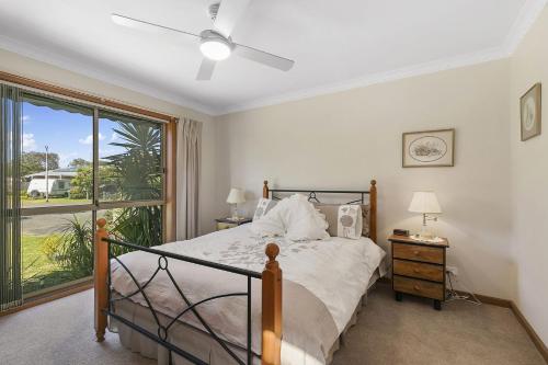 a bedroom with a bed and a large window at Peaceful Retreat Surf Side Pet Friendly Outside Only in Inverloch