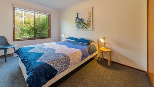 een slaapkamer met een bed en 2 ramen bij Pescarina in Inverloch