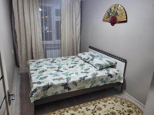 niewielka sypialnia z łóżkiem i oknem w obiekcie 2-х комнатная квартира по ул. Муратбаева w Kyzyłordzie