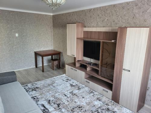 ein Wohnzimmer mit einem Flachbild-TV und einem Sofa in der Unterkunft 2-х комнатная квартира по ул. Муратбаева in Qysylorda