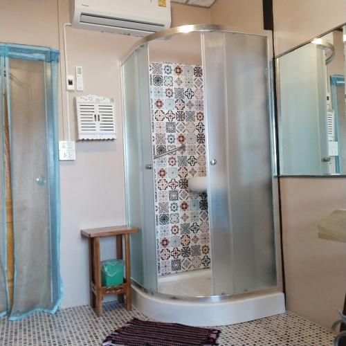a shower with a glass door in a bathroom at Ban Kru Ae HomeHostel in Bangkok