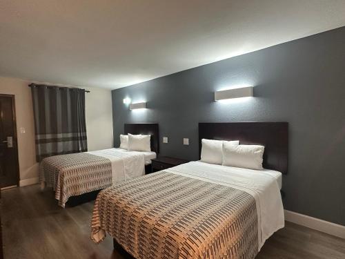キャロルトンにあるHotel Casa by Aryaの白いシーツが敷かれたベッドが2つあるホテルの部屋