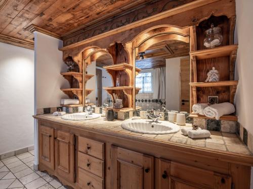 une salle de bain avec deux lavabos et un grand miroir dans l'établissement Luxueux Chalet à Courchevel avec Piscine, Hammam et Sauna - FR-1-613A-27, à Courchevel