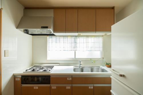 a kitchen with a sink and a stove and a window at Guest House Nishikanazawa Smile & smile - Vacation STAY 12106v in Kanazawa