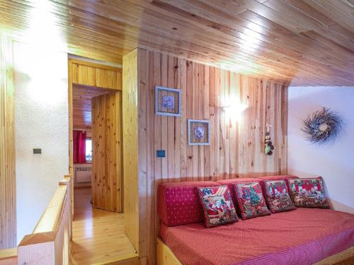 a bedroom with a red bed with wooden walls at Appartement Valmorel, 3 pièces, 6 personnes - FR-1-356-395 in Valmorel