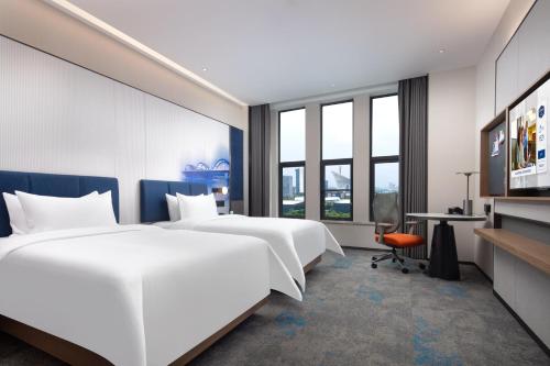 a hotel room with two beds and a desk at Hampton by Hilton Wuhan Optics Valley in Wuhan