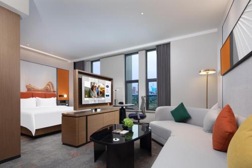 a living room with a white couch and a tv at Hampton by Hilton Wuhan Optics Valley in Wuhan