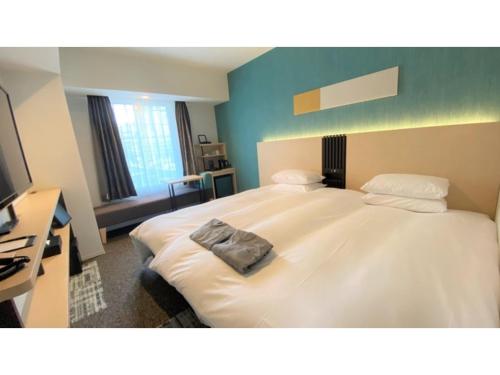 a large white bed in a room with a television at Tmark City Hotel Sapporo Odori - Vacation STAY 85615v in Sapporo