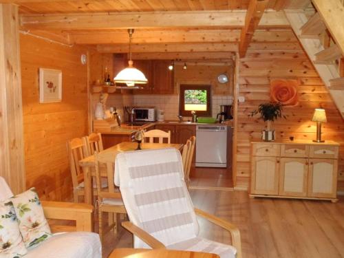 a kitchen and dining room of a log cabin at Holiday cottages near the sea, Sarbinowo in Sarbinowo