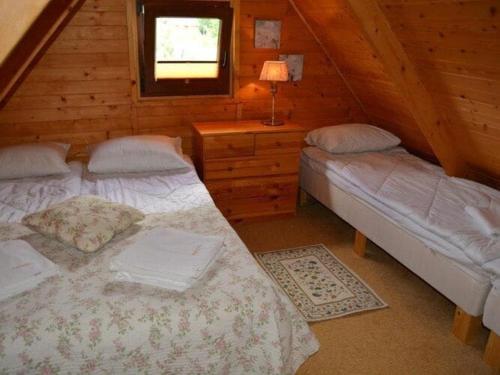 Dormitorio con 2 camas y cabina con TV en Holiday cottages near the sea, Sarbinowo en Sarbinowo