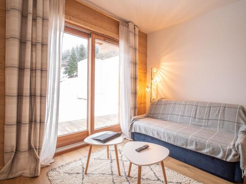 um pequeno quarto com uma cama e uma janela em Appartement Valmorel, 2 pièces, 4 personnes - FR-1-356-413 em Valmorel