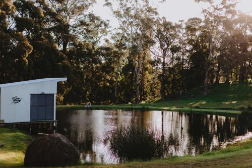 a small white building next to a lake at 17pounds Country Estate & Aqua Wellness Retreat in Bullarto
