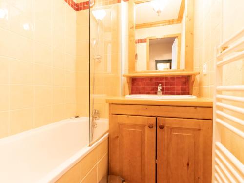 a bathroom with a tub and a sink and a mirror at Appartement Valmorel, 2 pièces, 4 personnes - FR-1-356-424 in Valmorel