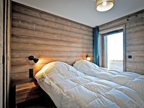 Cette chambre dispose de 4 lits et d'un mur en bois. dans l'établissement Spacieux appartement avec terrasse à 2 min des pistes, parking couvert et conciergerie - FR-1-613-98, à Les Allues