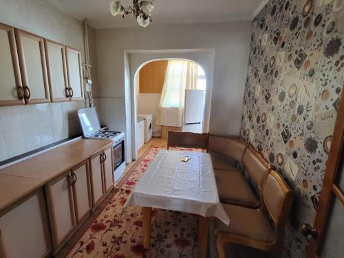 eine Küche mit einem Sofa und einem Tisch mit einem Laptop in der Unterkunft 3-х комнатная по ул. Есенова 19А in Qysylorda