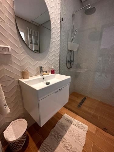 La salle de bains est pourvue d'un lavabo blanc et d'un miroir. dans l'établissement App avec jardin dans un hôtel, à Gammarth