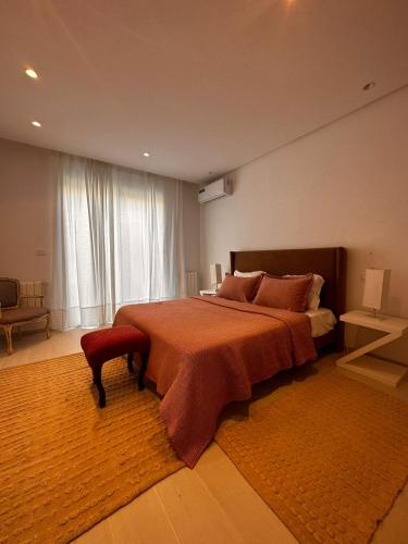 una camera con un grande letto e una grande finestra di App avec jardin dans un hôtel a Gammarth