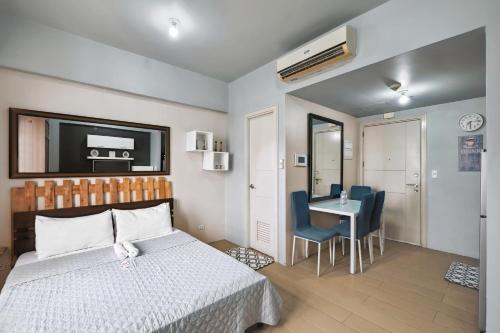 a bedroom with a bed and a table and chairs at Tess and Tessha Condotel in Manila