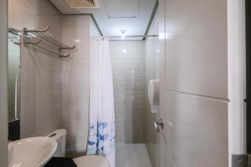 a bathroom with a shower and a toilet and a sink at Tess and Tessha Condotel in Manila