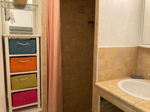 La salle de bains est pourvue d'un lavabo, d'une douche et de serviettes. dans l'établissement Appartement climatisé au centre-ville du Lavandou avec parking sécurisé et terrasse - FR-1-308-184, au Lavandou