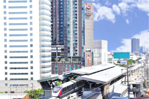 un treno in una stazione ferroviaria in una città di Best Western Plus Wanda Grand Hotel a Nonthaburi